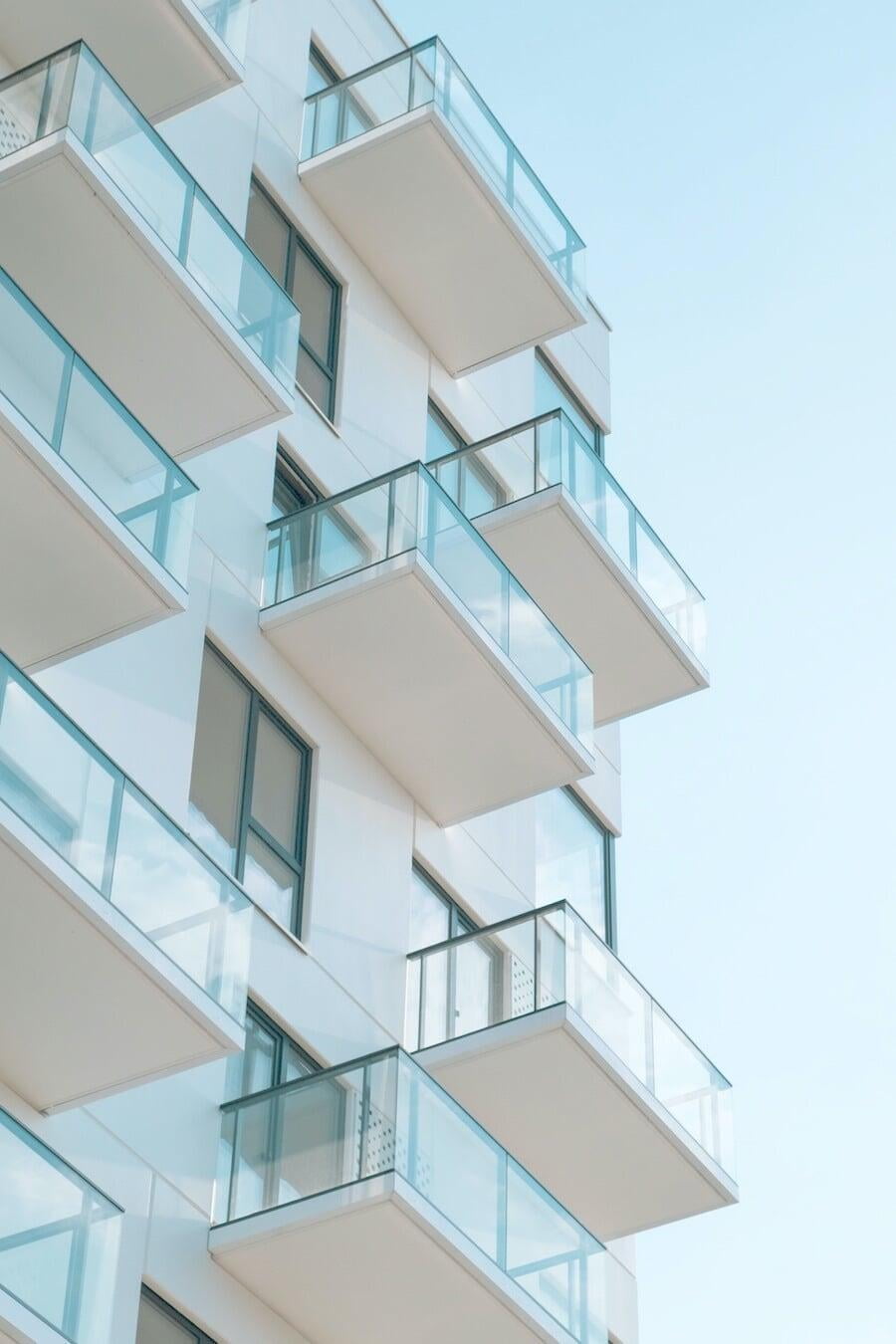 White multifamily apartment exterior with glass balconies